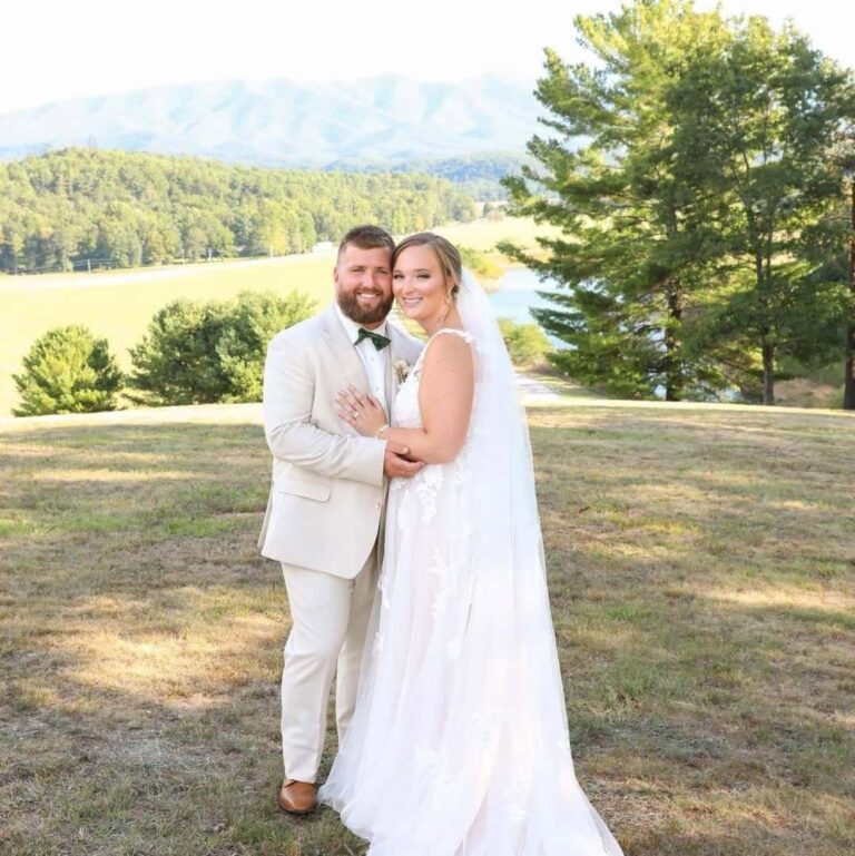 Bride and groom in a golden hour portrait with the farm fields and mountains behind