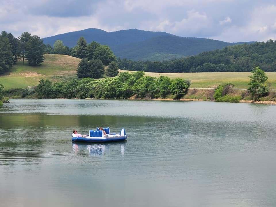 Guests out on the private lake in a paddle boat with the mountains rising behind